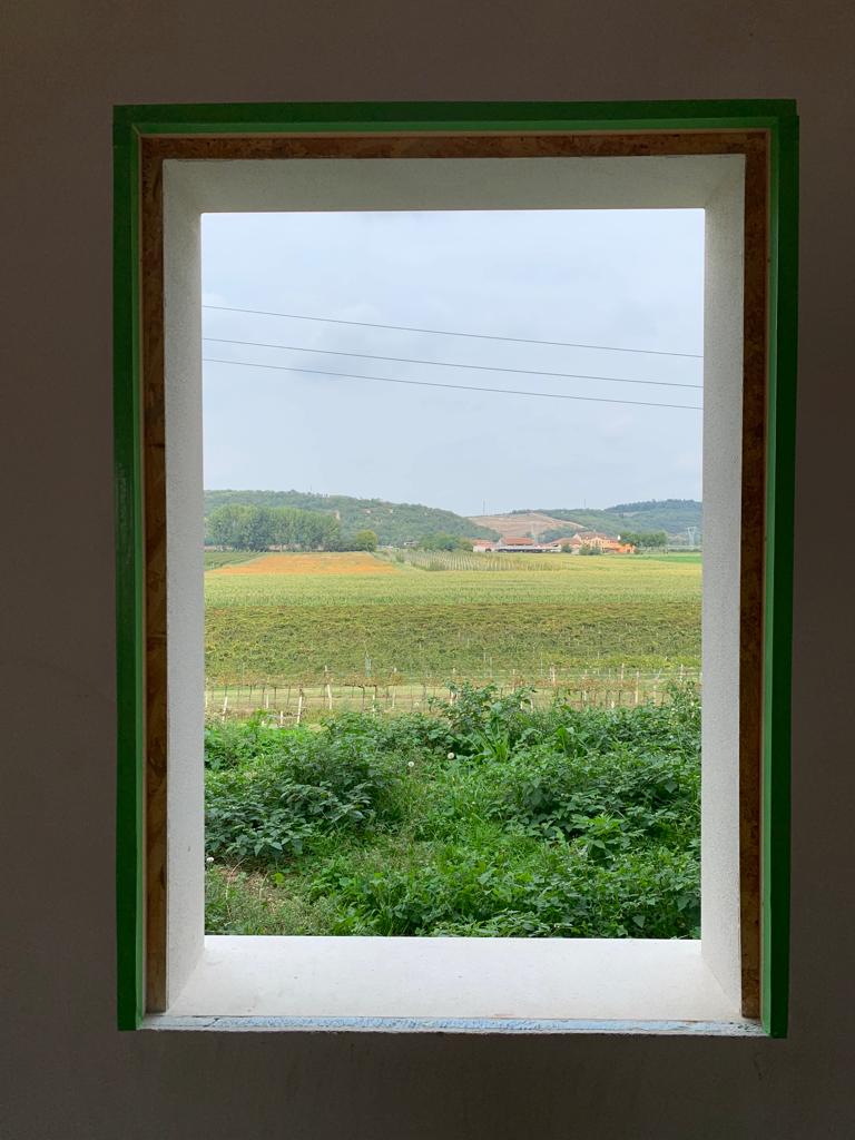 Vista frontale del vano finestra con intonaco di finitura e profili porta intonaco verdi installati.