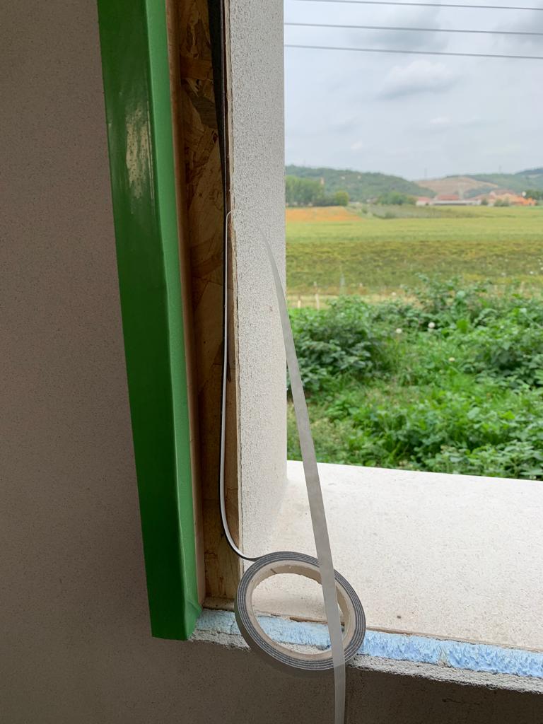Posizionamento del nastro termoacustico autoespandente sul profilo interno del controtelaio.